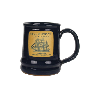 a blue ceramic mug with a ship on the front