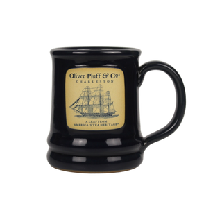 front of dark blue ceramic mug with oliver pluff logo and ship emblem