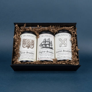 three tins in black gift box surrounded by crinkle paper