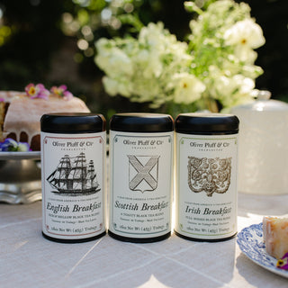 three tea tins sitting on tabletop in outdoor scene