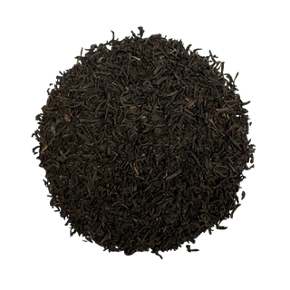 Round pile of dark brown tea leaves on a white background