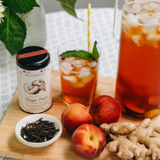 brewed glass of tea next too pitcher on wooden cutting board