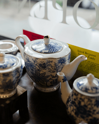 Blue and white ceramic teapots on a table with a blurred background