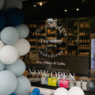 shop window with lettering that says 'Oliver Pluff's Tea Shop Charleston'