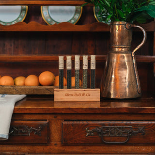 Wooden dresser with a copper pitcher, flowers, and a wooden box on top