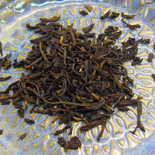 zoom in photo of cogou loose leaf tea on blue and yellow plate