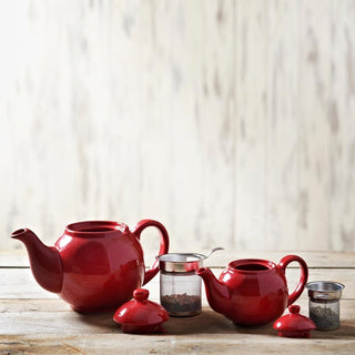 two red tea pots and two stainless steel filters