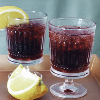 two iced glasses of tea with lemon slices sitting on bronze platter