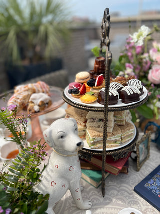 coffee, hot chocolate, flowers, desserts, dog statue center piece on decorated outdoor table