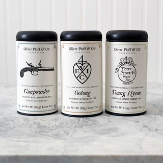 3 black tea tins in a row on marble counter