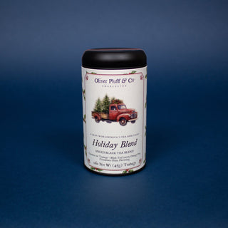 black tea tin with logo of red truck carrying green Christmas trees on label