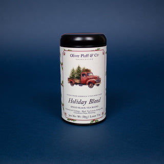 black tea tin with logo of red truck carrying green Christmas trees on label