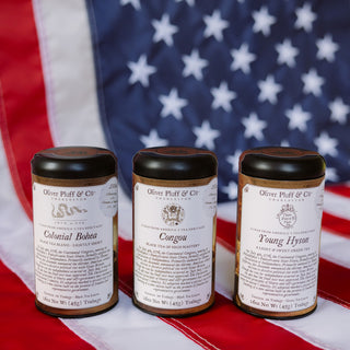 Three tea canisters with labels on an American flag background