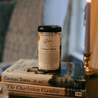 tea tin labeled Colonial Bohea 'Oliver Pluff & Co' on top of books with a blurred background