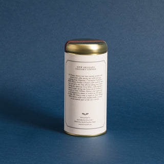 golden tea tin with brewing instructions on backside, against blue background