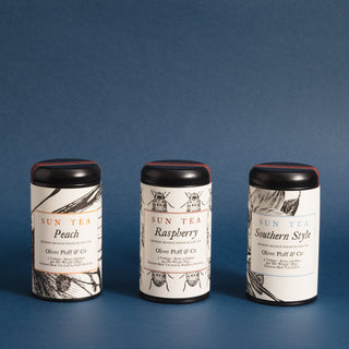 Three different One-Gallon Teabags in Signature Tins against blue background