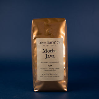 orange shiny bag of coffee sitting on blue back drop. Mocha Java whole bean coffee