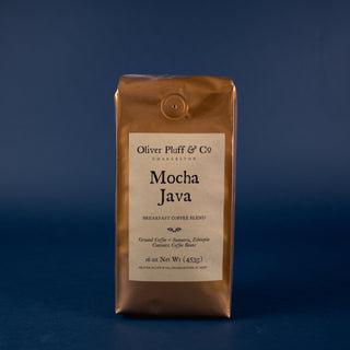 orange shiny bag of coffee sitting on blue back drop. Mocha Java ground coffee