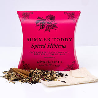 large red tea pouch with Cinnamon Sticks, Hibiscus Petals, Ginger, All Spice sprinkled in front on white counter