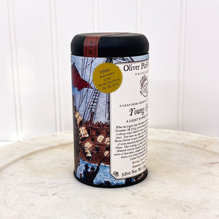 side view of black tea tin with graphic from boston tea party on white plate