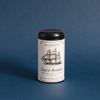 old timey ship graphic on black tea tin label, blue background