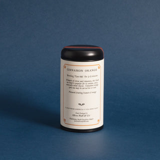 brewing instructions on backside of black tea tin with black and white graphic of orange on a limb. Blue background