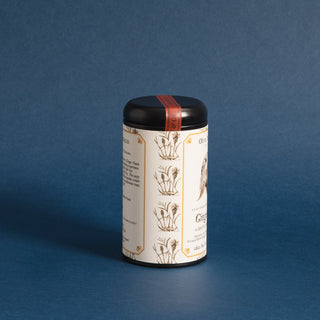 side view of single black tea tin with black and white graphic of a peach