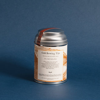 brewing instructions on small silver tea tin with orange flowery graphic and blue background