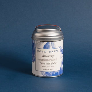 silver tea tin with blueberry graphics and blue backdrop