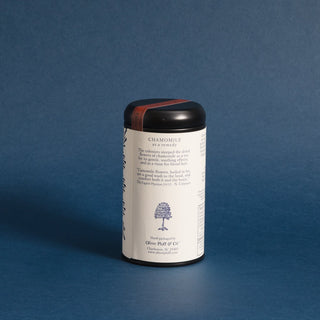 black tea tin with blue designs on label against blue backdrop