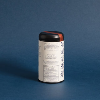 brewing instructions on black tea tin with blue designs on label against blue backdrop