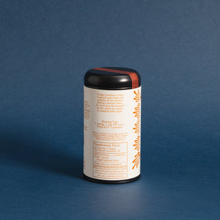 Brewing instructions on black tea tin with orange pattern against blue backdrop