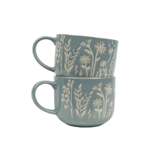Two stacked ceramic mugs with floral patterns on a white background