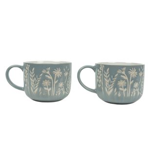 Two blue mugs with floral patterns on a white background