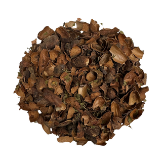 Pile of roasted brown cacao shells and peppermint leaves on a white background