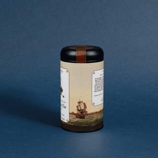 Cylindrical tea canister with decorative label on a blue background