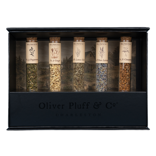 5 tubes of herbal tea with labels in black rectangular stand, inside a black gift box