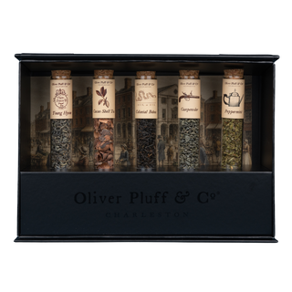 5 tubes of green, herbal or black teas with labels in black rectangular stand in black gift box with colorful background