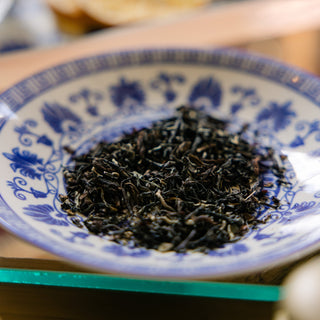 loose tea in ble and white dish on glass tabletop