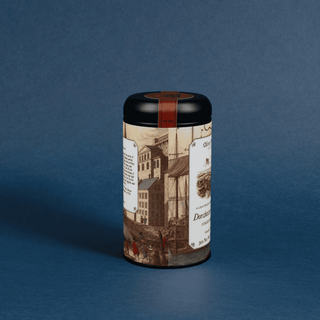 Cylindrical tea canister with decorative label on a blue background