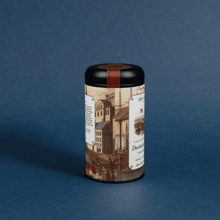 Cylindrical tea canister with decorative label on a blue background