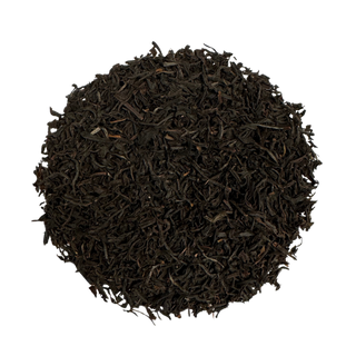 Round pile of dark brown tea leaves on a white background