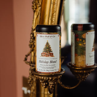 tea tin resting on gold framed mirror that reads 'holiday blend' with a christmas tree on the design