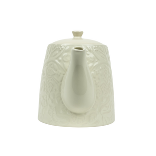 textured white teapot on white background