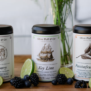 tea tin labeled key lime teabags on wood tray surrounded by fruit