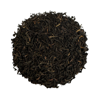 Close-up of dark brown tea leaves on a white background