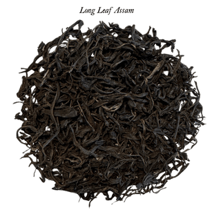 loose black tea leaves in round pile on clear background