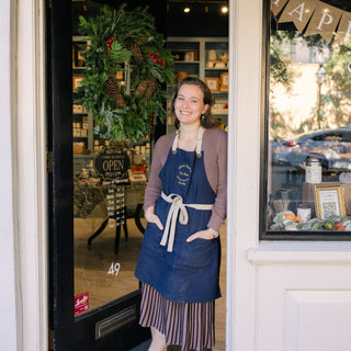woman standing in entrance of tea shop leaning against the wall 