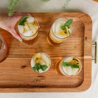 mango passionfruit iced tea in glasses shot from above, hand reaching for one glass