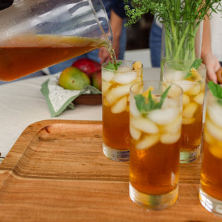 mango passionfruit iced tea in glass being served from pitcher